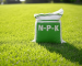 Sac d'engrais gazon NPK sur une pelouse, symbolisant l'apport d'azote, phosphore et potassium pour un gazon sain et luxuriant toute l'année.